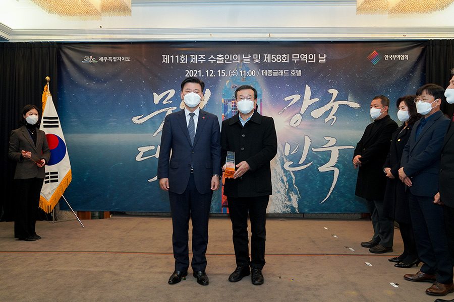 A BK bio representative holding the export award trophy for a photo at the ceremony