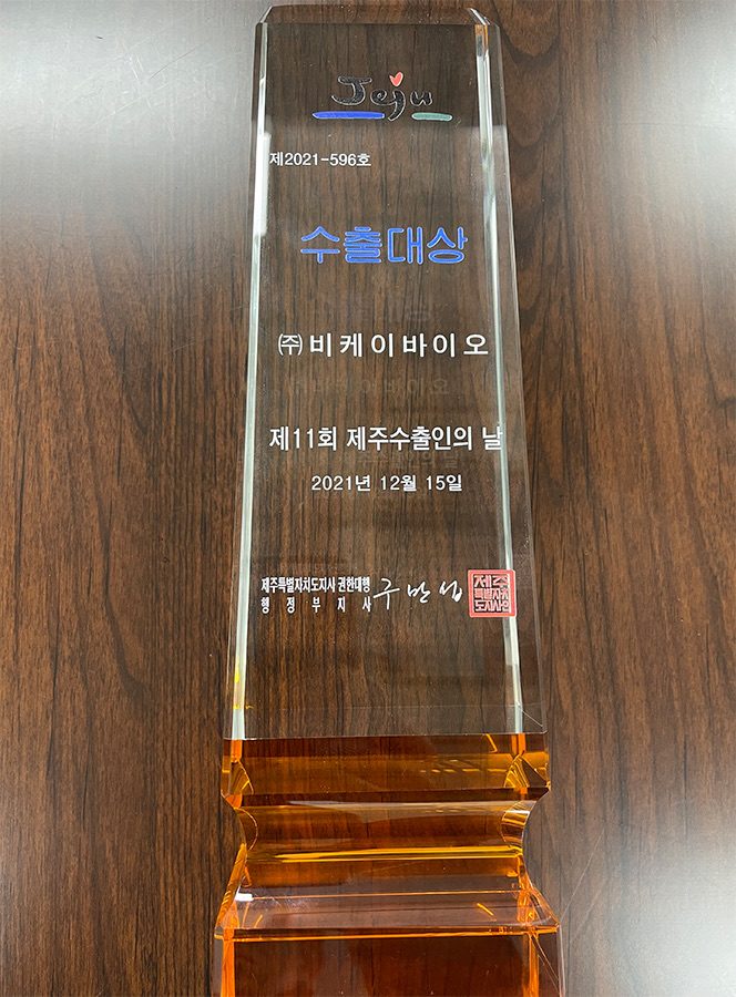 Close-up of the glass Jeju export award trophy presented to BK bio