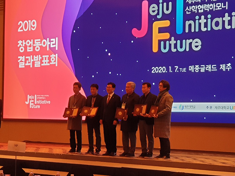 Award recipients holding plaques on stage at the 2019 Startup Club results presentation